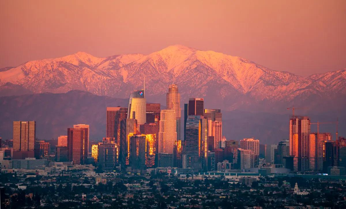 Horizonte de Los Ángeles al atardecer con montañas nevadas al fondo
